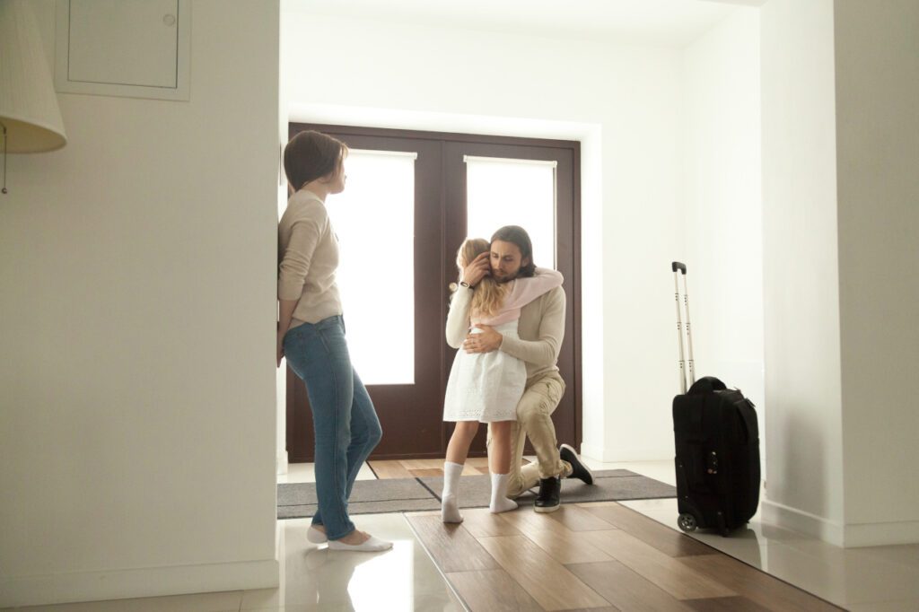 Child embraces mother as they pack their bags